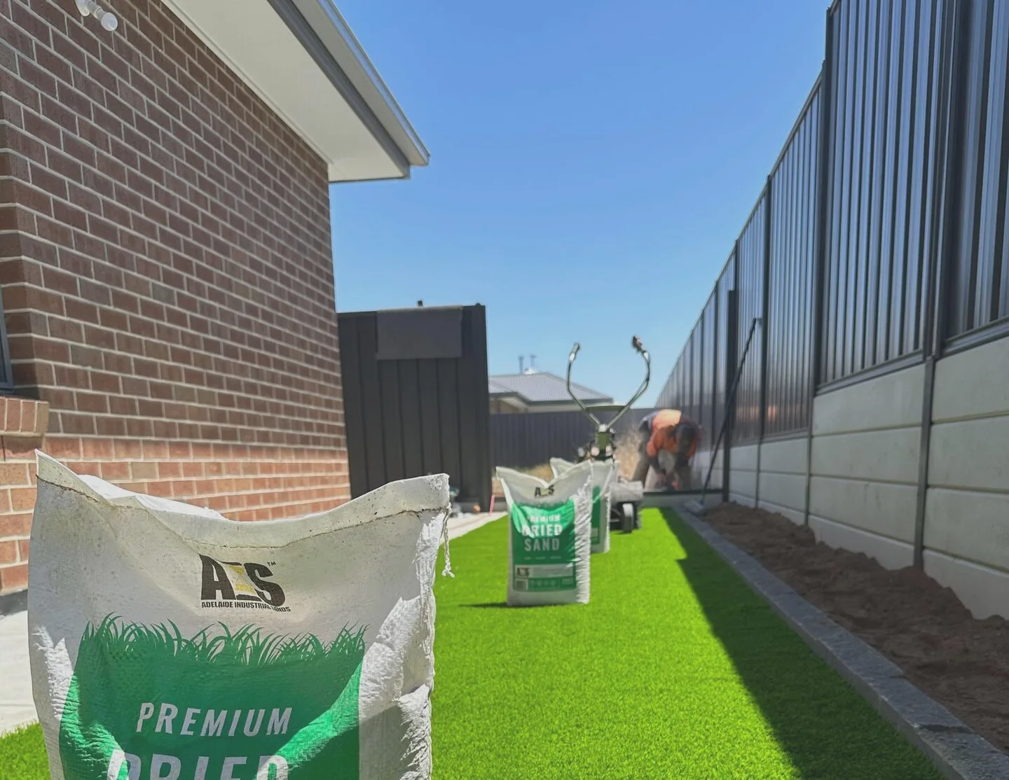 Synthetic turf installation in progress, showing base prep and edging